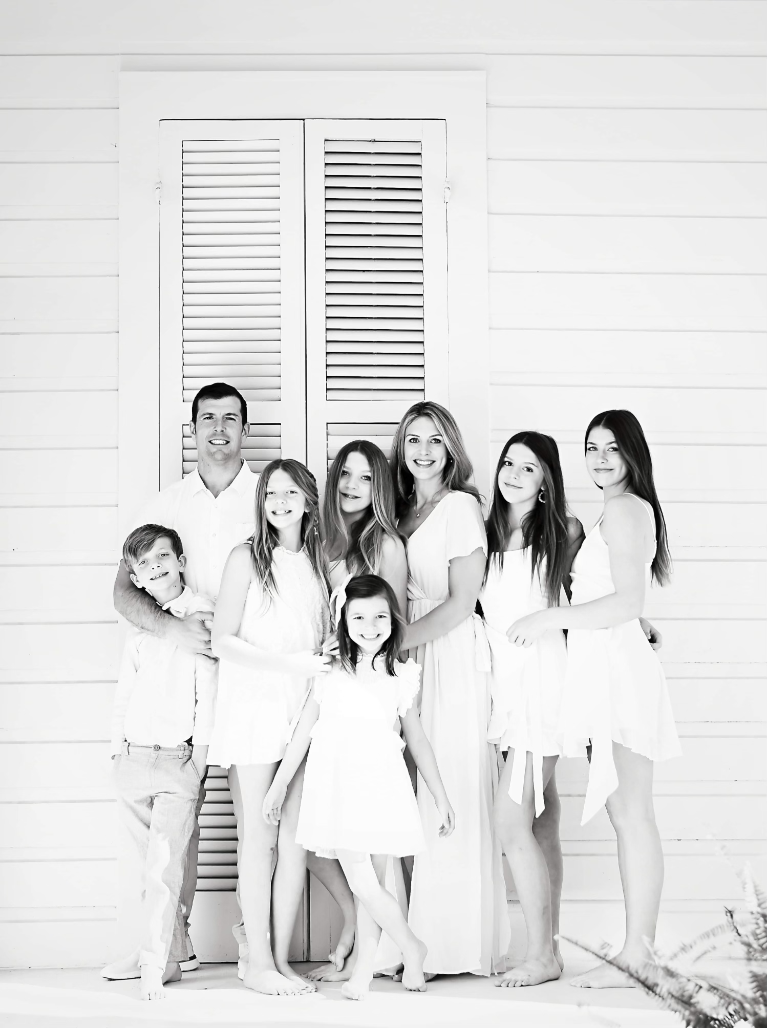 A family posing for a picture in front of a white door.